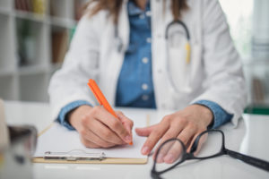 Female doctor writing medical records in the office