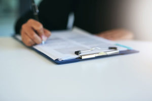 person filling out clipboard