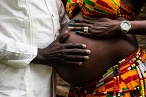 Pregnant woman and partner with hand on belly