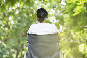 woman using a wheelchair in a park;