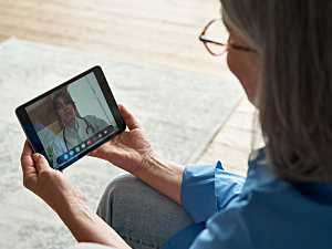 Patient uses a tablet for telehealth visit with doctor