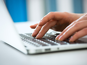 Close up of hands typing on a laptop