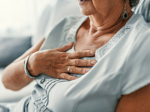 Older woman holding chest, GERD symptoms/discomfort