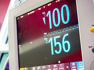 Close up of blood pressure monitor screen reading 100 over 156