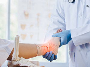 Doctor examining a patient's ankle wrapped and highlight red, orthopedic surgery recovery concept