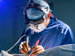 Neurosurgeon in special surgery glasses performing operation