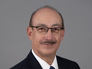 Headshot of A. Enrique Caballero, MD on gray background